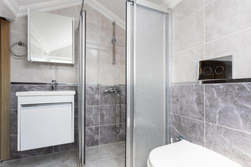 a bathroom with a shower with a toilet and a mirror at Villa Mazoya in Dalyan