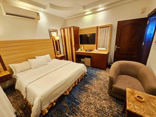 a hotel room with a bed and a chair at قصر البسمة للشقق المخدومةSMILE Serviced Apartments in Jeddah