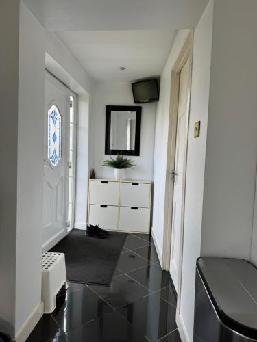 - un couloir avec une chambre dotée d'une commode et d'un miroir dans l'établissement Idyllic Cottage in Jubilee Park, à Londres