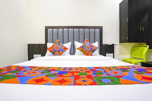 a bed with a colorful blanket on top of it at FabExpress Gulshan Grand in Mumbai