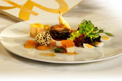 a white plate with food on a table at Hotel Rebstock Durbach in Durbach