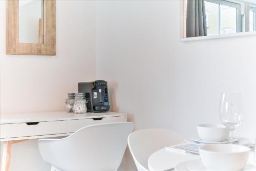 a white dining room with white chairs and a table at Fantastic Central Line City-pad! in London