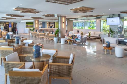 lobby restauracji ze stołami i krzesłami w obiekcie SERHS Experience Suítes w mieście Natal