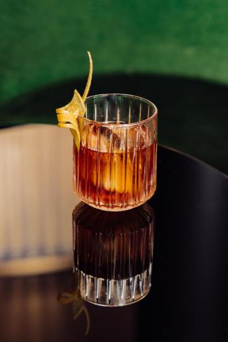 a drink in a glass sitting on top of a table at Roomers Munich, Autograph Collection in Munich
