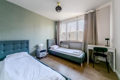 - une chambre avec un lit, un bureau et une fenêtre dans l'établissement Warsaw Concierge Pańska 61, à Varsovie
