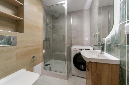 La salle de bains est pourvue d'une douche, d'un lavabo et d'un lave-linge. dans l'établissement Warsaw Concierge Pańska 61, à Varsovie