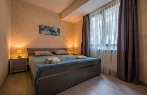 een slaapkamer met een bed en een groot raam bij Cozy place in Old Tbilisi in Tbilisi City