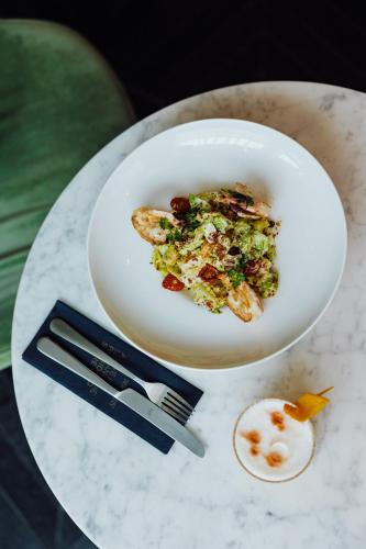 a white plate of food on a table at Roomers Munich, Autograph Collection in Munich