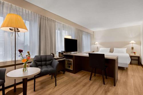 a hotel room with a bed and a desk at NH Noordwijk Conference Centre Leeuwenhorst in Noordwijkerhout