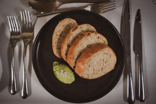 a black plate with a piece of bread and a pickle at Briery Wood Hotel in Ambleside