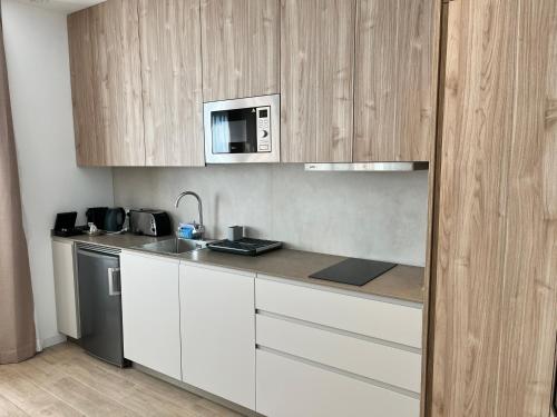 a kitchen with white cabinets and a microwave at Lumen Mare by SH Hoteles in Valencia