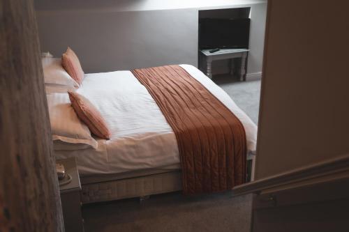 a bedroom with a bed with white sheets and pillows at Briery Wood Hotel in Ambleside