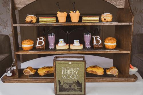 a bakery display with bread and pastries on a shelf at Briery Wood Hotel in Ambleside