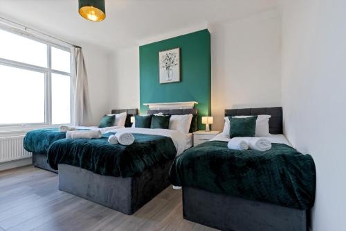 2 Betten in einem Zimmer mit Grün und Weiß in der Unterkunft Stylish 2 Bed Apartment near Central London in London