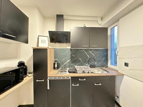 een keuken met grijze kasten en een aanrecht bij Sam Apartments in Muhlheim am Main