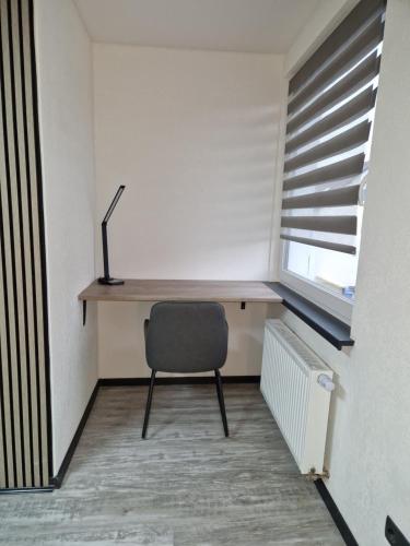 een bureau in een kamer met een stoel en een raam bij Sam Apartments in Muhlheim am Main