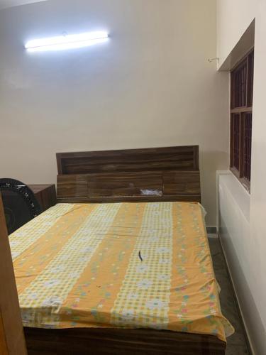 a bedroom with a bed with a yellow blanket on it at 164 N Ashiyana in Lucknow