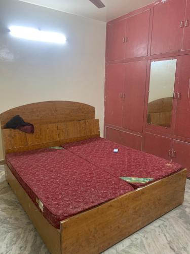 a bed in a room with red cabinets at 164 N Ashiyana in Lucknow