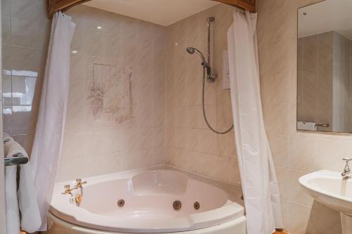 a bathroom with a tub and a sink at Briery Wood Hotel in Ambleside