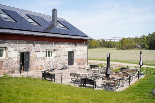 a building with chairs and tables and a solar roof at Hotel Stallbacken Nagu in Nauvo