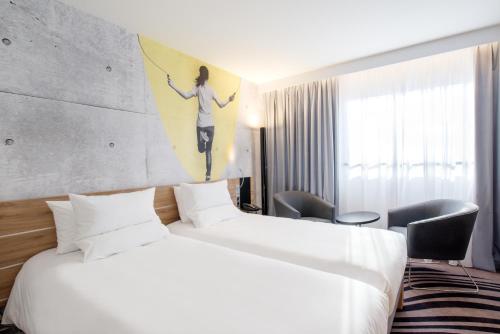 a hotel room with two beds and a painting on the wall at Novotel Warszawa Centrum in Warsaw