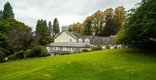 a large house on a hill with a green yard at Briery Wood Hotel in Ambleside
