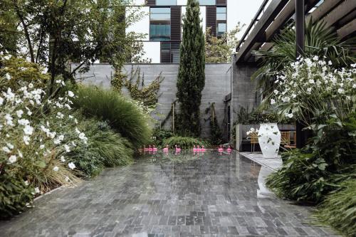 a garden with pink chairs and white flowers at Roomers Baden-Baden, Autograph Collection in Baden-Baden