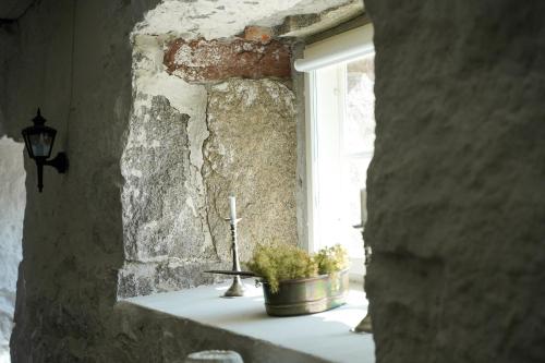 a window with a cross and a plant on a window sill at Hotel Stallbacken Nagu in Nauvo