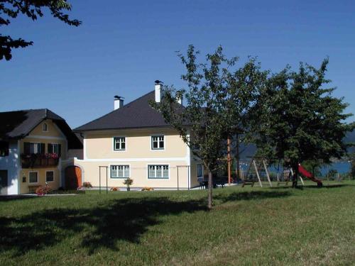 a white house with a tree in front of it at Landgut Wagnerfeld in Altmünster