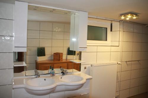 uma casa de banho com um lavatório e um espelho em Ferienhaus Winterberg für 12 Personen Sauna Garten Garage Hund em Winterberg