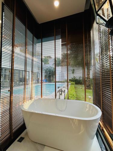 a bath tub in a room with a large window at Menara - 3 BR Private Pool Villa - Moroccan Inspired - Bangtao Beach in Phuket