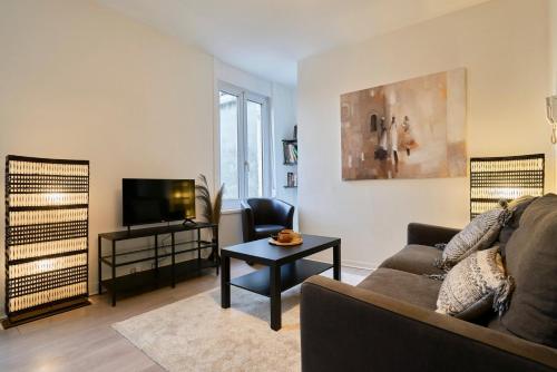 sala de estar con sofá y TV en One bedroom apartment near tramway & shops, en Mouvaux