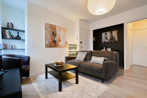 un salon avec un canapé et une table dans l'établissement One bedroom apartment near tramway & shops, à Mouvaux