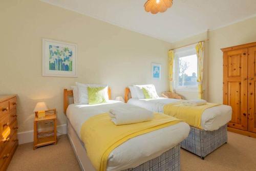 a bedroom with two beds and a window at Stonesthrow Elie, 2 Mins to Beach, Free Parking in Elie
