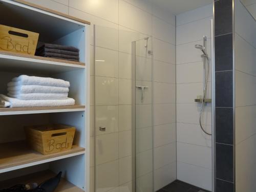 a bathroom with a shower and white towels at Hangar 19 Seebrise in Schwerin
