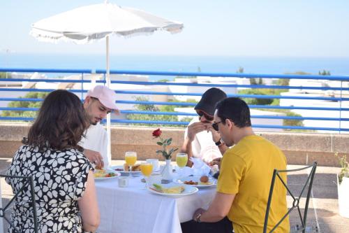 a group of people sitting at a table eating food at Lunja Village - Agadir in Taghazout