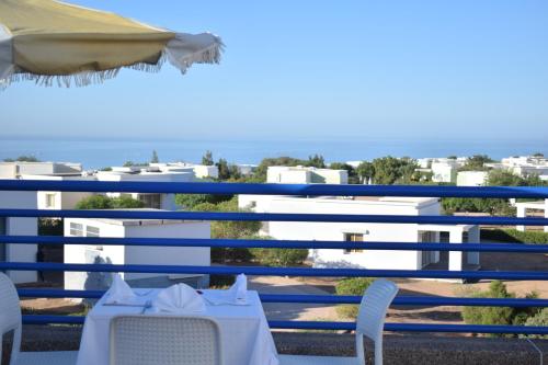 a table and chairs on a balcony with the ocean at Lunja Village - Agadir in Taghazout
