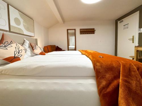 a bedroom with a large white bed with a blanket on it at Sieben Zimmer am See in Prien am Chiemsee