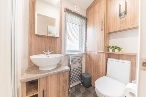 a bathroom with a white toilet and a sink at Tastefully decorated lodge on popular holiday park, easy access to Lakes and Dales and free parking in Carnforth
