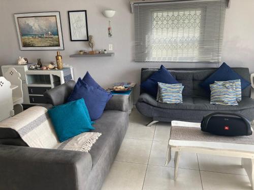 a living room with two couches and blue pillows at OCEAN GARDENS 5 in Margate