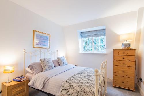 1 dormitorio con 1 cama, vestidor y ventana en The Linen House by Bloom Stays, en Canterbury