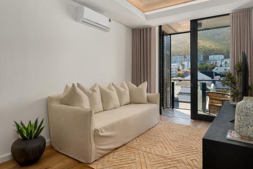 a living room with a couch and a balcony at Station House Apartments in Cape Town