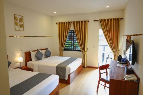 a hotel room with two beds and a window at Nimith Hotel & Restaurant in Phnom Penh