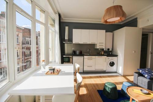 une cuisine et un salon avec une grande fenêtre dans l'établissement Fully-equipped apartment in city center + parking, à Lille