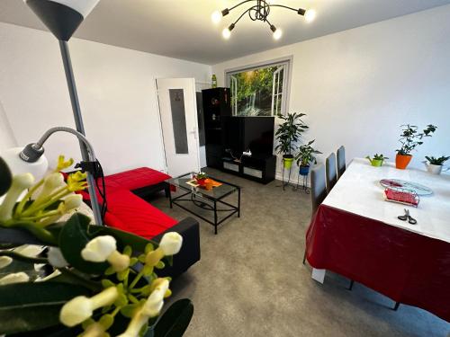 uma sala de estar com um sofá vermelho e uma mesa em Les Dômes du Parc 4e App T3 et T1 proche de toutes commodités em Clermont-Ferrand