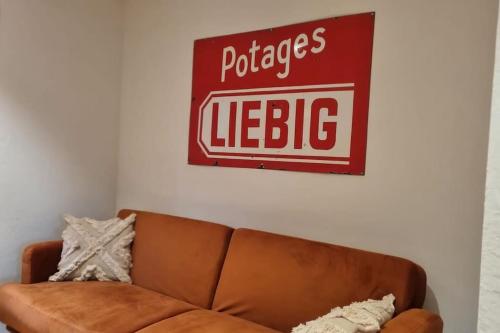 a sign hanging on a wall above a couch at Un séjour plein de charme aux Posses! in Gryon
