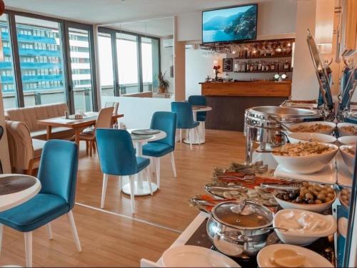 ORBI CiTY-sea view aparthotel في باتومي: بوفيه طعام على طاولة في مطعم