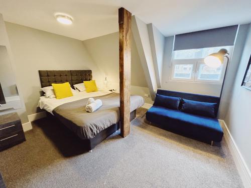 1 dormitorio con cama, espejo y silla en 2 Bedroom Apartment in the Heart of Newcastle - Modern - Sleeps 4, en Newcastle