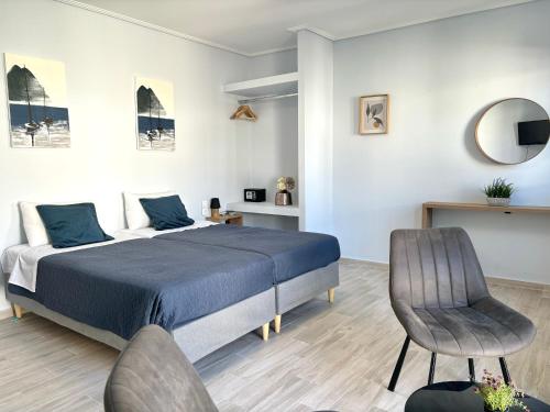 una camera con letto, sedia e specchio di Nelly's Luxury Suites a Kassiopi