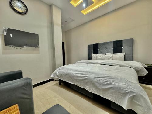 a bedroom with a large bed with a clock on the wall at Millat Hotel G9-1 in Islamabad
